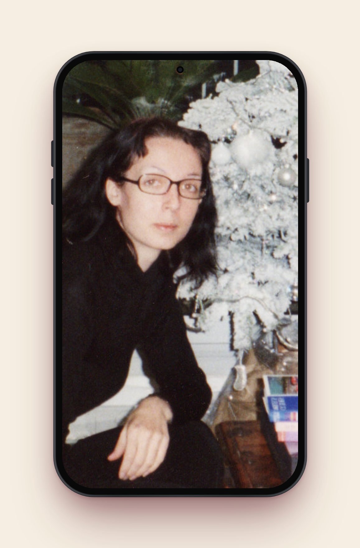 Angélique Olivia, aged 20, sitting in front of a white Christmas tree