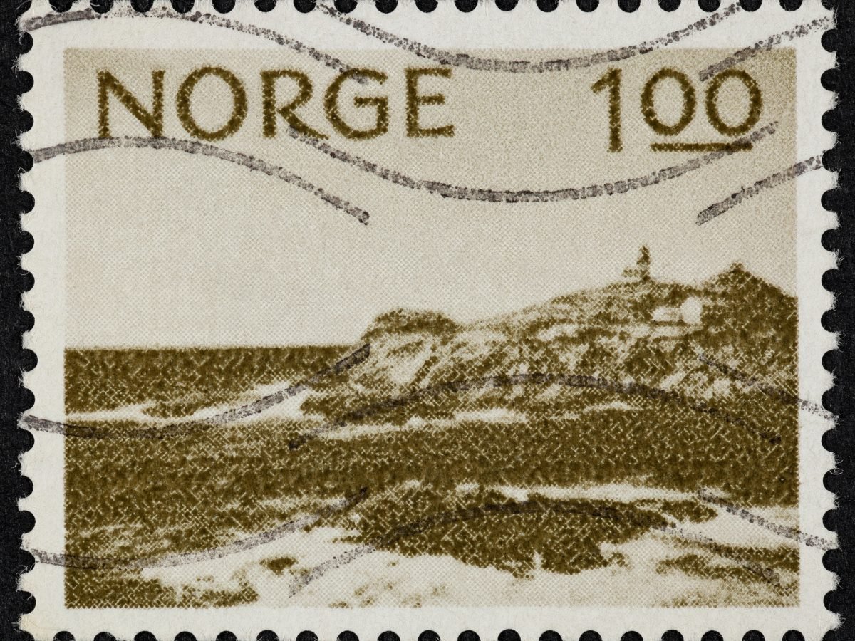 Used Norwegian stamp marked NORGE, showing a coastal landscape and a lighthouse