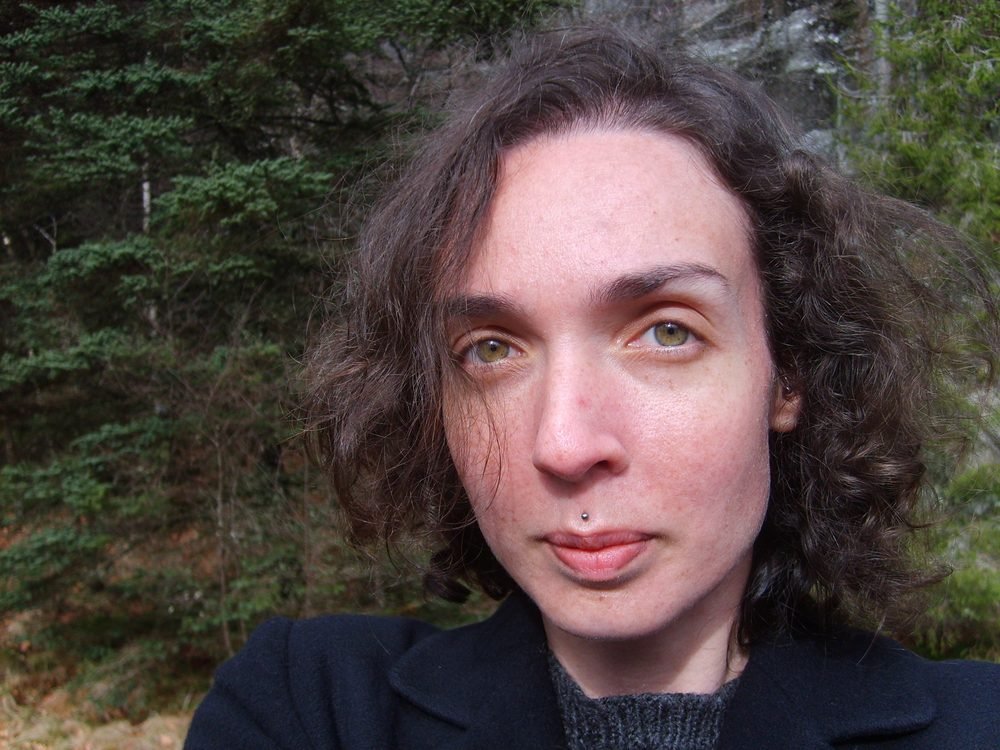 Selfie d’Angélique Olivia au sommet du mont Fløyen, devant des sapins